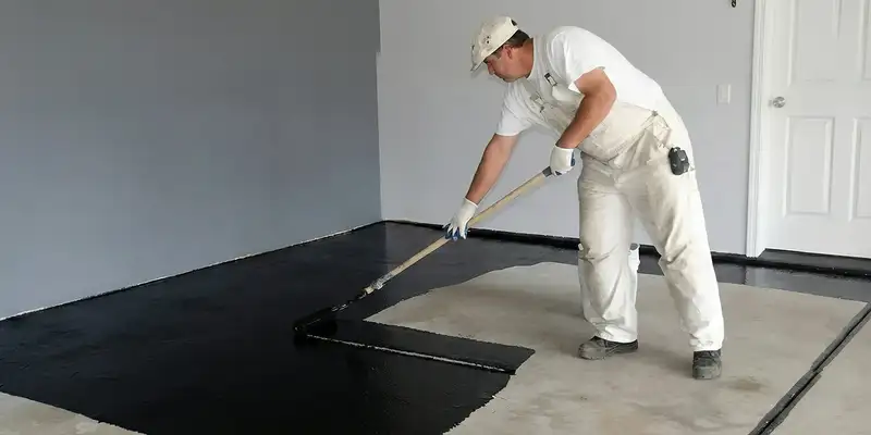 basement waterproofing professional applying waterproof coating to protect a basement floor in Dallas, TX