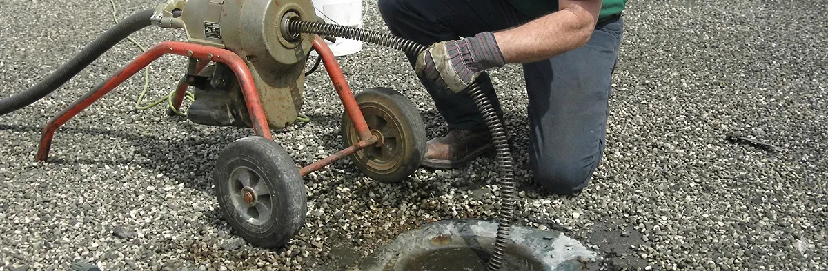 sewer rodding technician actively removing blockages from a sewer line in Dallas, TX