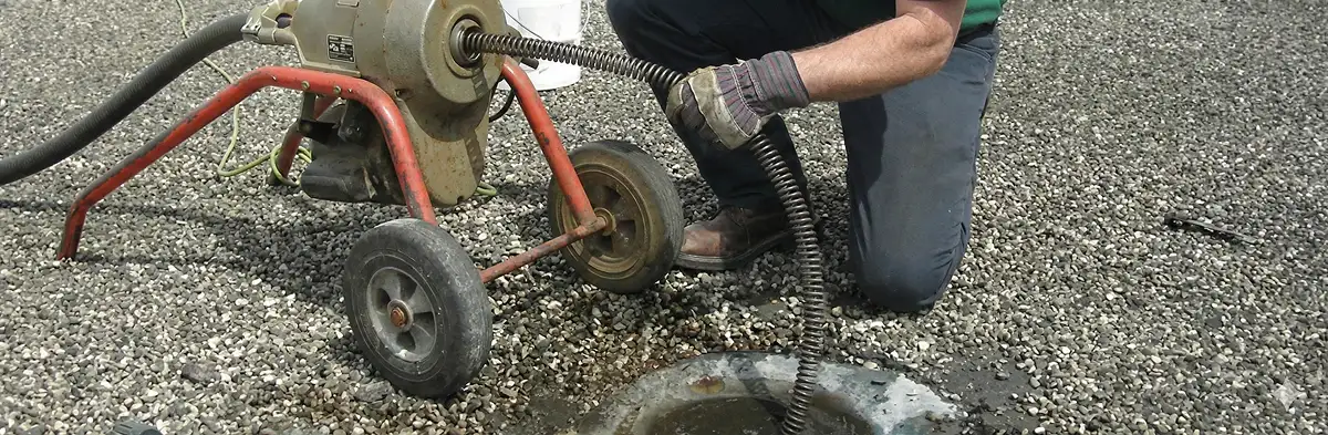 sewer rodding technician actively removing blockages from a sewer line in Dallas, TX